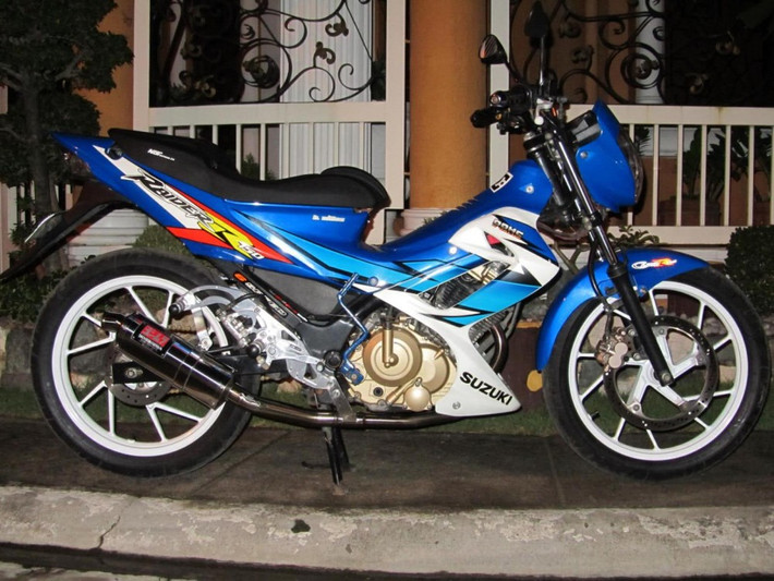 Suzuki Raider 150 vẫn "làm mưa làm gió" trên thị trường Việt và là nguồn cảm hứng bất tận của những tay chơi chuyên độ xe. Điểm nổi bật nhất của chiếc Suzuki Raider 150 này có lẽ là chiếc pô Yoshimura và giò đạp Stinger 120. Pô Yoshimura với lon tam giác thích hợp với hầu hết các loại xe và có giá khoảng 1 triệu đồng.