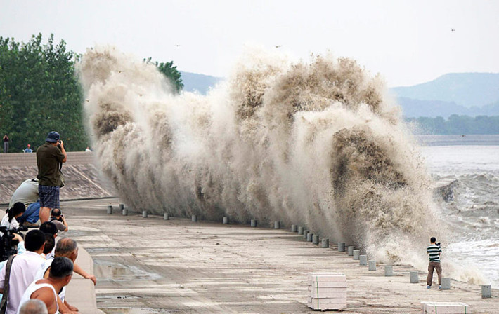 Mọi người chụp ảnh và quay phim khoảng khắc sóng thủy triều dâng cao.