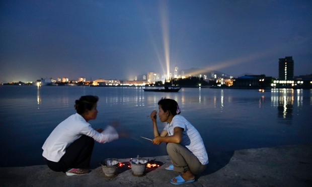 Những người phụ nữ nói chuyện bên cạnh các lò nướng hải sản tại một âu tàu ở Wonsan.
