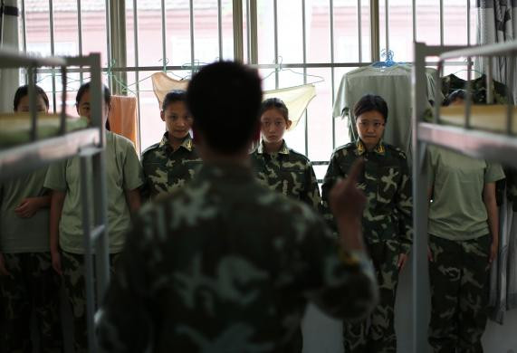 Một giáo viên hướng dẫn phổ biến quy định cho các học viên nữ tại ký túc xá.