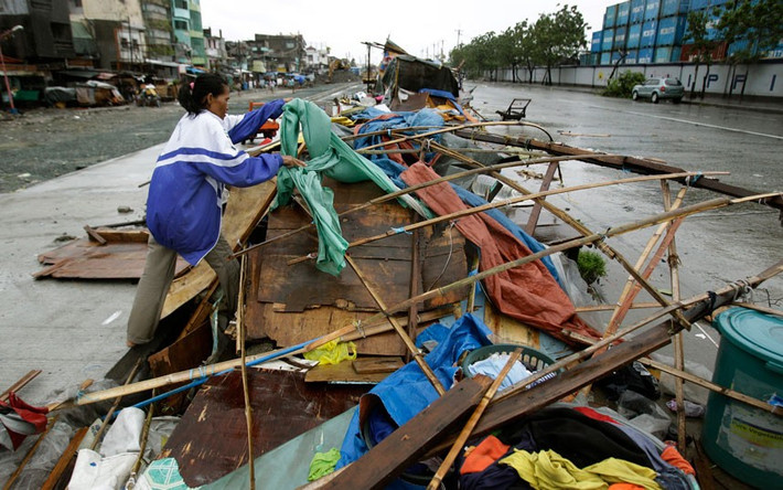 Một người dân thu dọn ngôi nhà tạm bị gió bão tàn phá ở ngoại ô Navotas.