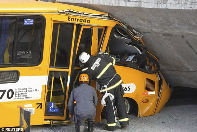 Nhân viên cứu hộ kiểm tra chiếc xe bus gặp nạn.
