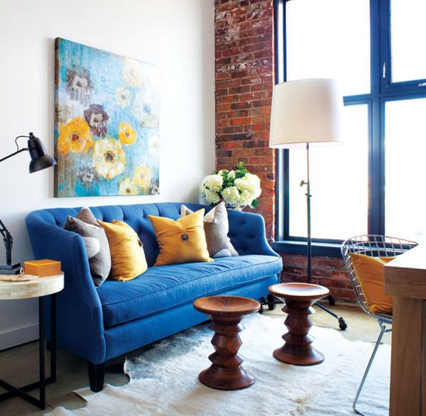 Một chiếc sofa xanh cô-ban sẽ làm cho phòng khách của bạn ấn tượng và thời thượng hơn. Ngoài ra, nó còn tăng độ sáng cho căn phòng, góp phần làm nổi bức tường được trang trí bằng gạch thô và đồ nội thất bằng gỗ.