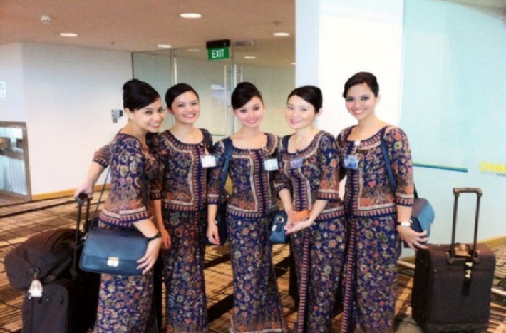 Diện bộ váy thổ cẩm sang trọng và quyến rũ, nữ tiếp viên Singapore luôn thân thiện chu đáo, đem lại cảm giác thoải mái tối đa cho khách hàng.