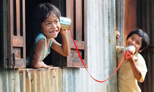 Bé Siu Toan và bé H’Nhâm (trái) chơi trò gọi điện thoại bằng ống bơ ở làng Plei Ốp, TP Pleiku (Gia Lai) - Ảnh: Hồ Anh Tiến.