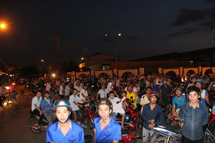 Hàng trăm người hiếu kỳ đứng bên ngoài theo dõi lực lượng chức năng làm công tác chữa cháy.