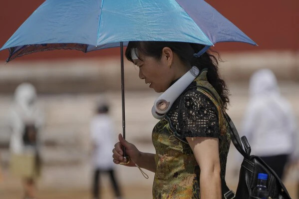 Đợt sóng nhiệt này đã khiến nhiều khu vực trên thế giới bao gồm Việt Nam, Thái Lan, ẤN Độ, Trung Quốc, Mỹ, Mexico phải hứng chịu nắng nóng kinh hoàng và khiến người dân gặp nhiều khó khăn trong sinh hoạt và mưu sinh hàng ngày. Các chuyên gia cảnh báo rằng nhiệt độ kỷ lục có thể bị phá thêm vài lần nữa trong năm nay. Ảnh: Người phụ nữ trang bị đầy đủ thiết bị tránh nóng như ô, quạt, miếng dán, nước lọc