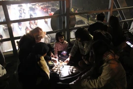 Hà Nội: Người dân ngồi đánh bài, chơi cờ trên cầu vượt chờ xem pháo hoa