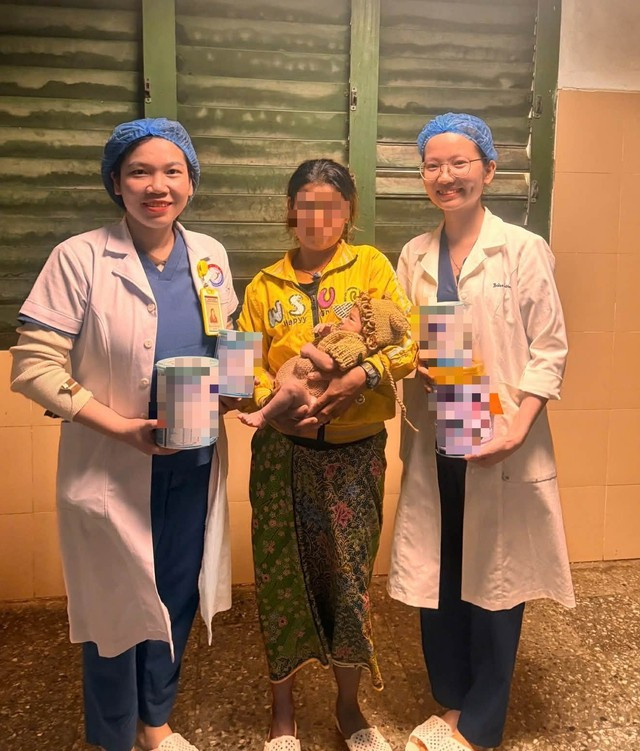 Hai mẹ con sản phụ và các y bác sĩ chụp ảnh trong ngày bé được ra viện. Ảnh SKĐS