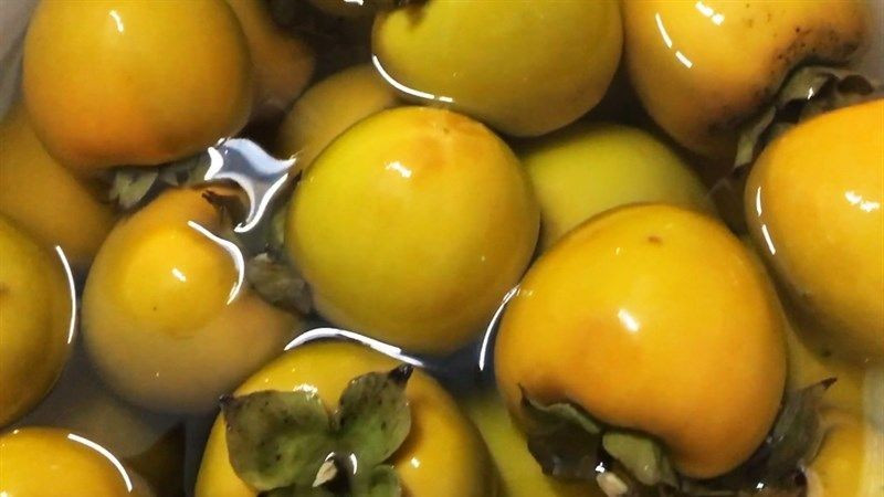 Ngâm nước hồng trước khi ăn để giảm độ chát. Ảnh minh hoạ/Internet