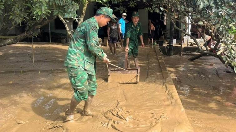 Cán bộ, chiến sĩ Bộ đội Biên phòng tỉnh Nghệ An giúp đỡ nhân dân dọn dẹp bùn đất sau lũ/Ảnh nhandan.vn.