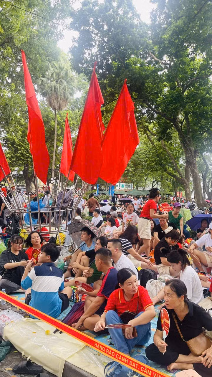 Cô Nhị (áo đen, hàng đầu tiên) đã trải bạt, giữ chỗ ngồi từ đêm hôm qua (31/8).