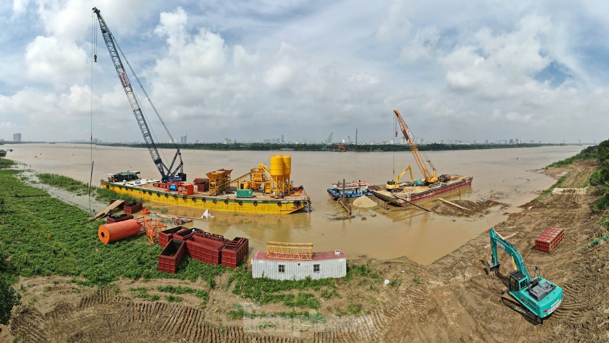 Công nhân cùng các trang thiết bị máy móc đang thi công trụ cầu phía quận Long Biên.