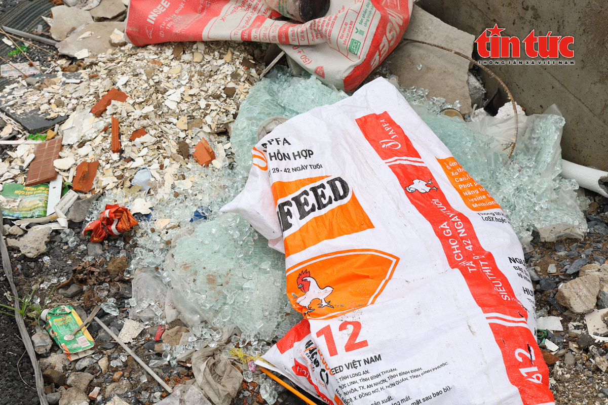 Mảnh kính vỡ không che chắn, vứt bừa bãi ngay trên vỉa hè, đe dọa an toàn người đi đường.