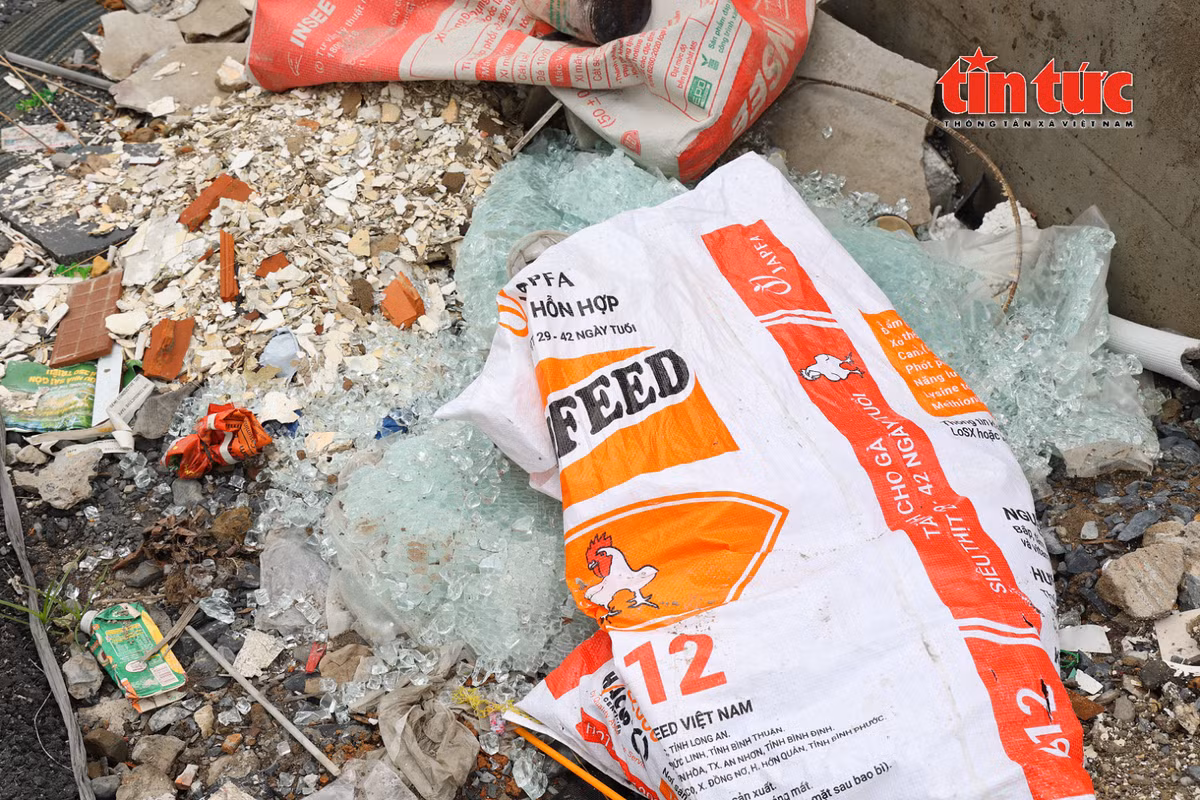 Mảnh kính vỡ không che chắn, vứt bừa bãi ngay trên vỉa hè, đe dọa an toàn người đi đường.