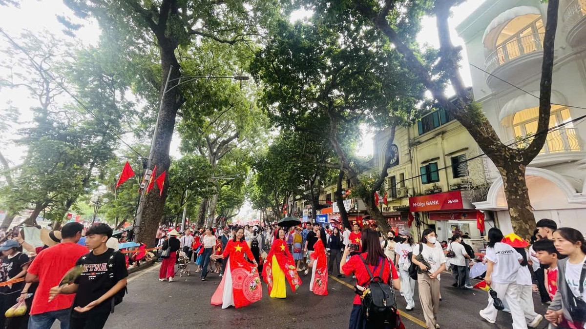 Một số người dân mặc áo dài có in hình cờ đỏ sao vàng chụp ảnh lưu lại kỷ niệm "80 năm Quốc khánh".