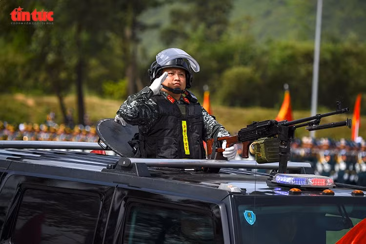 Chiến sĩ Cảnh sát cơ động thực hiện động tác chào trong tư thế sẵn sàng chiến đấu trên xe bọc thép.