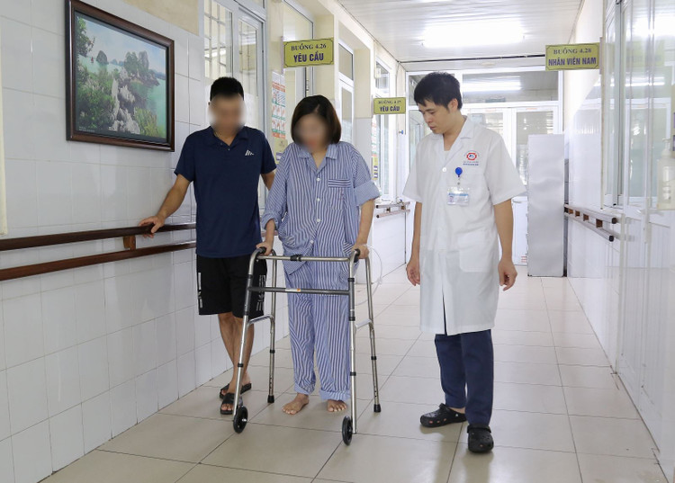 Bệnh nhân sau phẫu thuật được bác sĩ hướng dẫn tập vận động, tập đi lại bằng khung tập đi - Ảnh BVCC gay-xuong-1.jpg