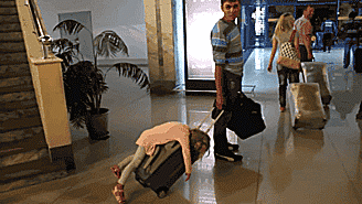 Em bé ngủ ngay trên vali của bố. Ảnh: Brightside.