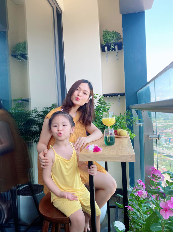 Ban công thiết kế đơn giản với bàn gỗ dài, vài chậu hoa, cây cảnh nhưng vẫn đủ tạo thành góc thư giãn, chụp ảnh đẹp long lanh.