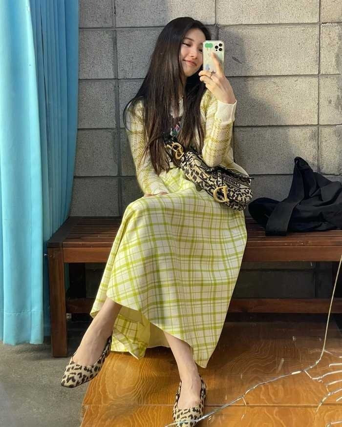 Suzy đầy trẻ trung thanh lịch với set đồ kẻ được mix matchy matchy đồng điệu. Diện áo sweater kẻ caro tông màu vàng sáng cùng chân váy dài ton sur ton.