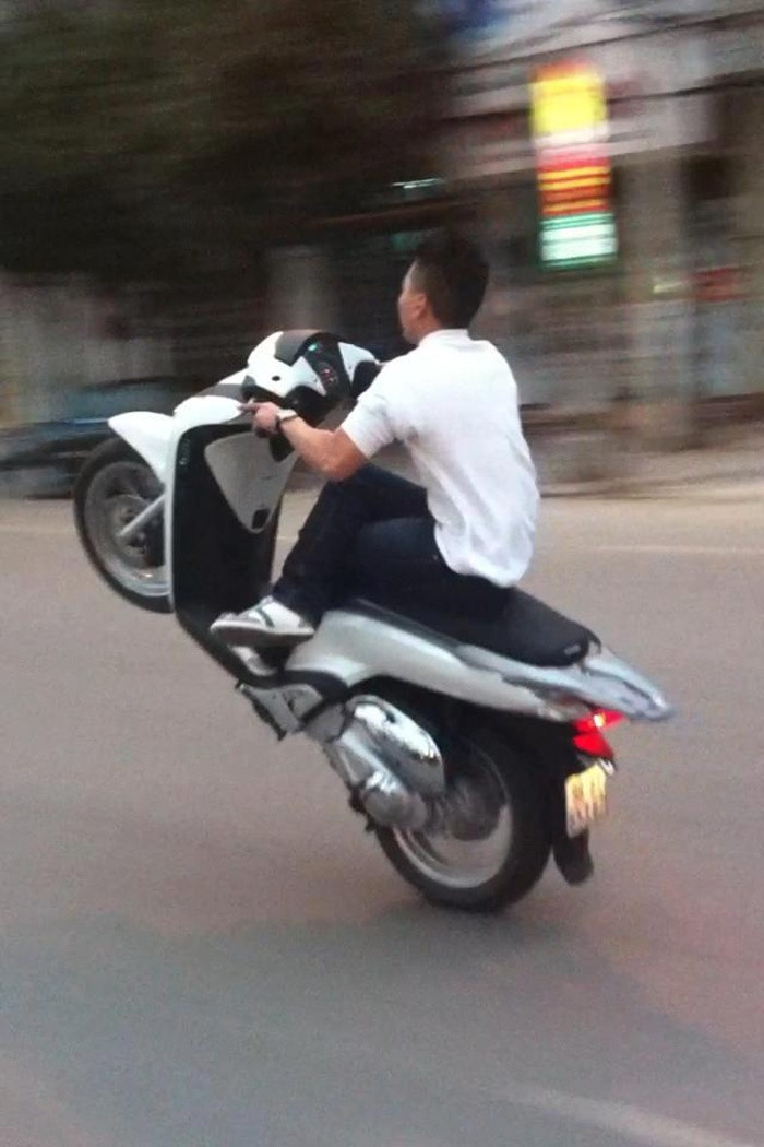 ...không đội mũ bảo hiểm, vắt chéo chân điều khiển giao thông.
