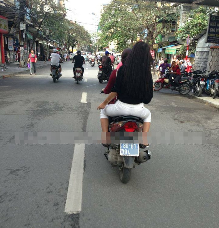 Hai thiếu nữ này điều khiển xe máy biển xanh cấp Bộ lưu thông trên phố Hàng Giấy (Hà Nội), cả hai đều không đội mũ bảo hiểm.