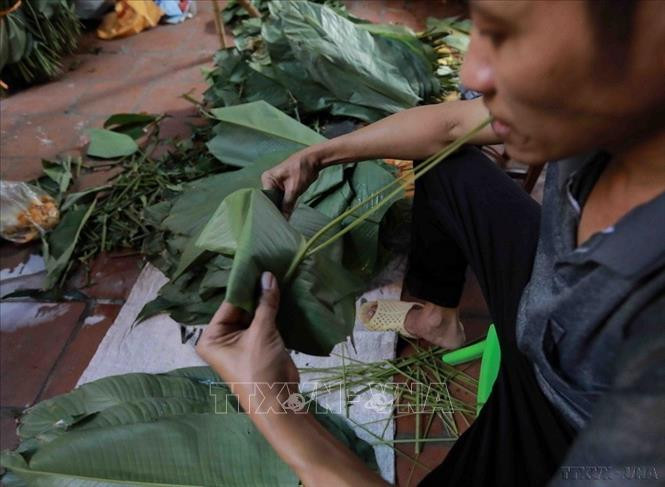 Lá dong sau khi được rửa sạch, lau khô thì đem tước sống lá để khi gói bánh không bị gãy, bánh vuông, đẹp. Ảnh: Vũ Sinh/TTXVN