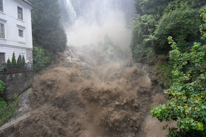 Nước lũ mang theo bùn đất tràn qua thác nước ở trung tâm Bad Gastein, Áo, ngày 28/8. Ảnh: Getty.