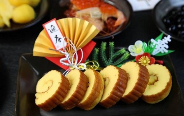 Datemaki (trứng cuộn ngọt): Datemaki là món trứng tráng cuộn ngọt trộn với tương cá. Nó được cuộn lại bằng cách sử dụng một tấm mành tre để tạo ra các vết lõm, khiến cho miếng trứng khi được cắt ra trông giống như một cuộn giấy thời xưa. Vì thế món ăn này được xem như lời cầu chúc về trí tuệ và tri thức.
