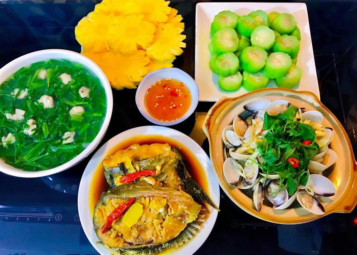 ổi thực đơn với cá mè kho lá nghệ, nghêu hấp sả, canh rau muống nấu nghêu, mướp luộc và tráng miệng dứa. Đồ hải sản tươi sống hay được chị Tình ưu tiên khi thiết kế thực đơn. Dù giá thành không quá rẻ nhưng vì các con, chị sẵn sàng đầu tư. Bên cạnh đó, chị tăng cường bổ sung rau xanh để thanh lọc, điều hòa cơ thể.