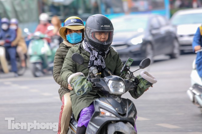 Dùng găng tay ấm khi di chuyển bằng xe máy cho ấm người. (Ảnh: Tiền Phong).