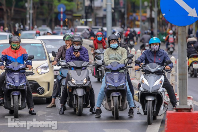 Tại một khu vực dừng đèn đỏ nhiều người vẫn co ro mặc dù đã mặc nhiều lớp áo. (Ảnh: Tiền Phong).