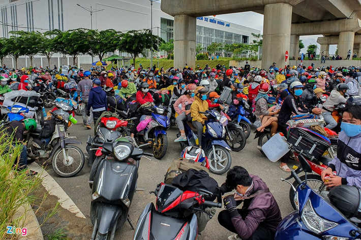 Phía trước cổng Bến xe Miền Đông cũng tập trung đông người muốn rời TP.HCM. Những người này đa phần có quê miền Trung. Khi nghe TP.HCM áp dụng cách ly xã hội thêm một tháng, họ quyết định khăn gói về quê.