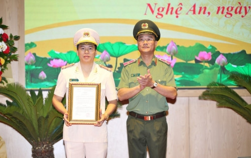 Thừa ủy quyền của Bộ trưởng Bộ Công an, Thiếu tướng Phạm Thế Tùng, Giám đốc Công an tỉnh trao Quyết định cho Đại tá Trần Hồng Quang, Phó Giám đốc Công an tỉnh Nghệ An. (Ảnh Minh Khôi)