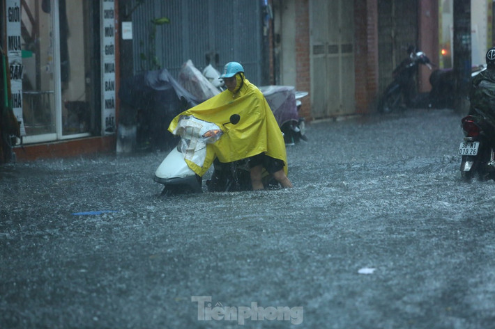 Nhiều phương tiện bị chết máy giữa phố ngập nước. (Ảnh Tiền Phong)