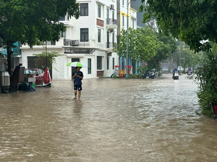 Người dân lội nước bì bõm trên đường.