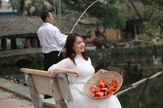 Cô gái tha thướt trong những tà áo dài trắng kết hợp với sắc đỏ của hoa gạo tạo nên những bức ảnh giản dị mà đẹp đẽ, có sức hút lạ kỳ.
