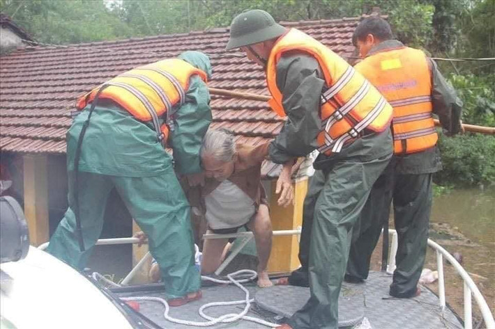 Người già được lực lượng chức năng giải cứu khỏi vùng bị cô lập do lũ.