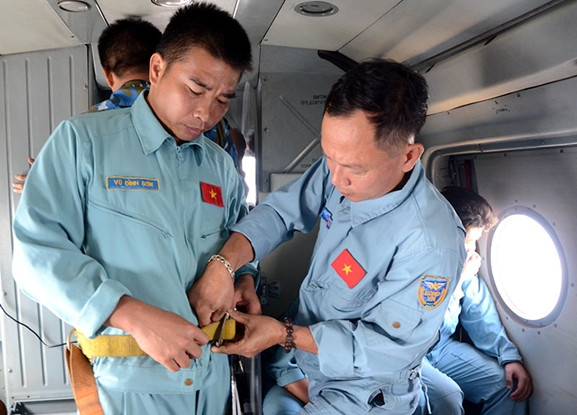 Nhân viên cứu hộ của Trung đoàn 930 thắt dây an toàn chuẩn bị thả hàng cứu trợ.