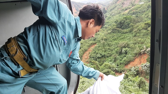 Vì điều kiện thời tiết không cho phép hạ cánh, nên trực thăng của Trung đoàn 930, Sư đoàn 372 bay treo thả hàng cứu trợ người dân vùng lũ.