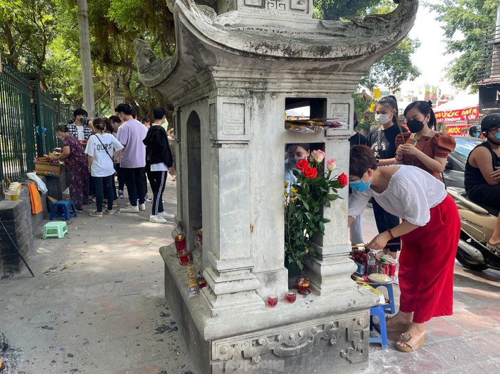 Người dân tranh thủ hóa vàng ngay tại hàng rào Văn Miếu - Quốc Tử Giám sau khi hành lễ.