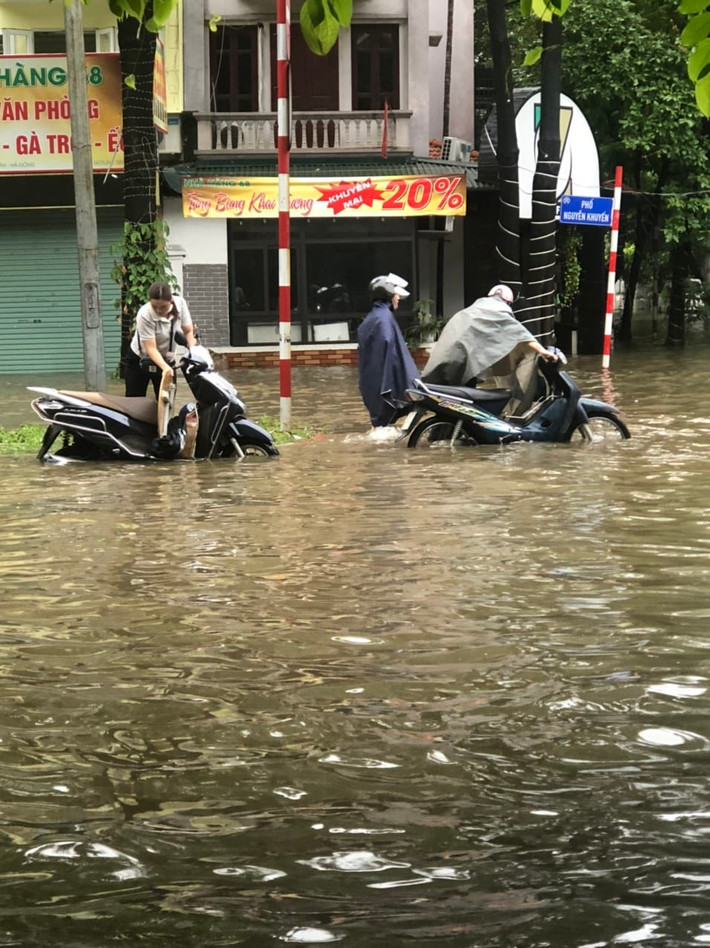 Nhiều người phải dắt phương tiện qua đoạn ngập sâu tại khu vực đường Nguyễn Khuyến.