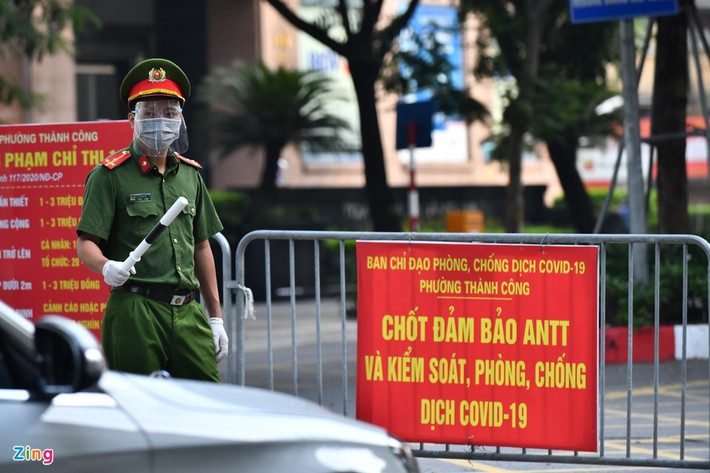 Thượng uý Lê Anh Dũng làm nhiệm vụ rà soát giấy người đi đường tại một chốt trên phố Giảng Võ. Tuy nhiên, để tránh tình trạng bị ùn ứ ở đầu chốt vào sáng thứ hai đầu tuần, nhiều chốt chặn phải nhanh chóng để cho xe đi qua.