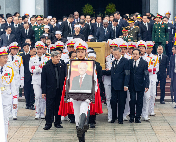 Các đồng chí lãnh đạo Đảng, Nhà nước cùng đại diện gia đình đưa Linh cữu Đồng chí Tổng Bí thư ra Linh xa. (Ảnh CAND)