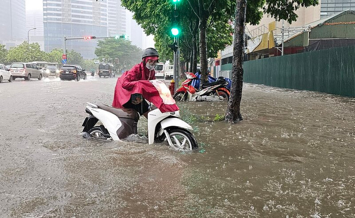 Tại đường Dương Đình Nghệ, nước ngập sâu hơn nửa bánh xe, chủ phương tiện không thể di chuyển, phải dắt bộ.