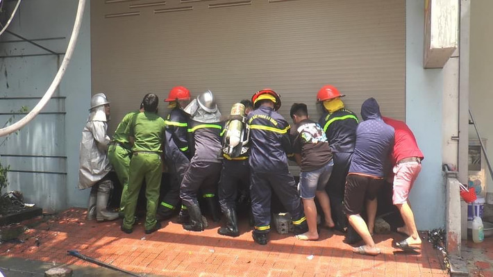 Ngọn lửa có dấu hiệu lan sang ngôi nhà 4 tầng bên cạnh quán bia. Lực lượng chức năng phối hợp cùng người dân cậy cửa ở ngôi nhà này để khống chế ngọn lửa.