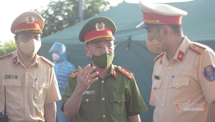 Anh Dương cho biết, khi đi qua các tỉnh, anh chỉ cần có giấy xét nghiệm test nhanh là được thông qua, nhưng khi ra tới đây lại yêu cầu phải có xét nghiệm PCR, nên thực sự anh không biết phải làm như thế nào. Sau khi được tổ công tác giải thích, anh Dương đành chấp nhận quay đầu xe ngược lại theo quy định của TP Hà Nội. (Đại tá Trần Ngọc Dương, Phó Giám đốc Công an TP Hà Nội kiểm tra tại chốt Pháp Vân - Cầu Giẽ. Ảnh: Vũ Điệp)