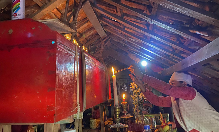 Chiếc quan tài của cụ bà Nguyễn Thị Linh được các con treo lên sát trần nhà để tránh lũ. Diện tích chỗ này chỉ khoảng 2 m2, người nhà thắp hương cho cụ Linh phải bò hoặc quỳ, chứ không đứng thẳng người được. (Ảnh: Vnexpress).