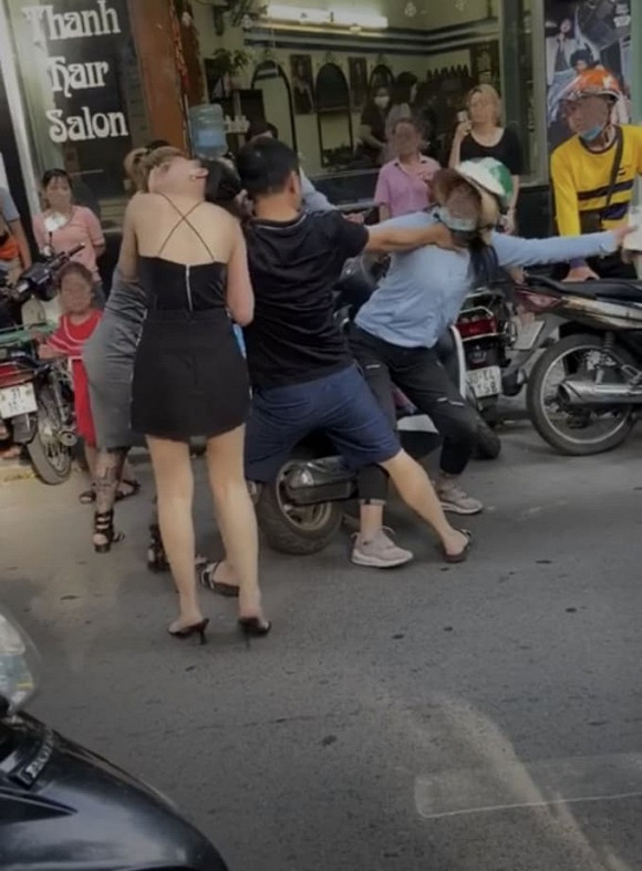 Chồng đánh vợ dã man ngay trên phố để bảo vệ nhân tình: Khoảng 16h chiều 15/9, người phụ nữ (đội mũ xanh) được cho là vợ đã chặn cô nàng bồ nhí (áo 2 dây đen) để chửi mắng và xảy ra giằng co trên phố Lý Nam Đế, Hà Nội.
